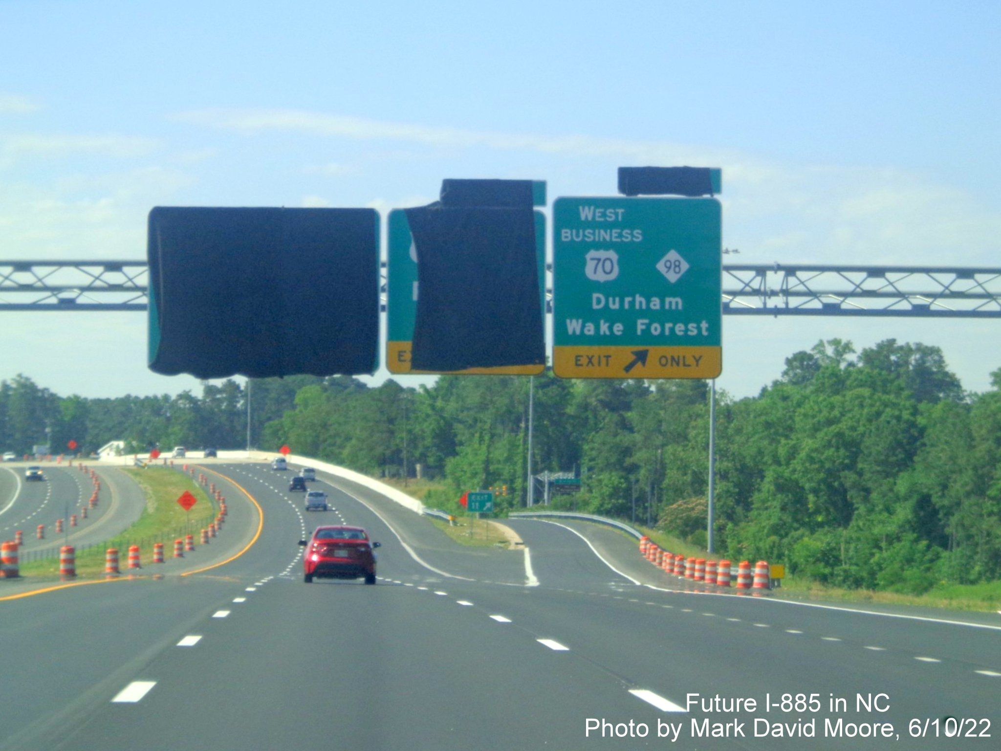 Image of overhead signage at ramp for US 70 Bus. West/NC 98 exit
       with exit tab still covered over on Future I-885 South/US 70 East in Durham, by Mark David Moore June 2022
